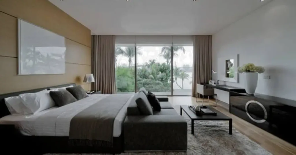 A contemporary bedroom with expansive windows offering a breathtaking ocean vista, reflecting the Black Room Aesthetic.